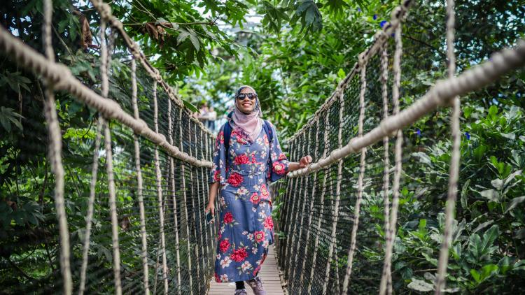 Woman on the wobbly bridge in Eden Project's Rainforest Biome