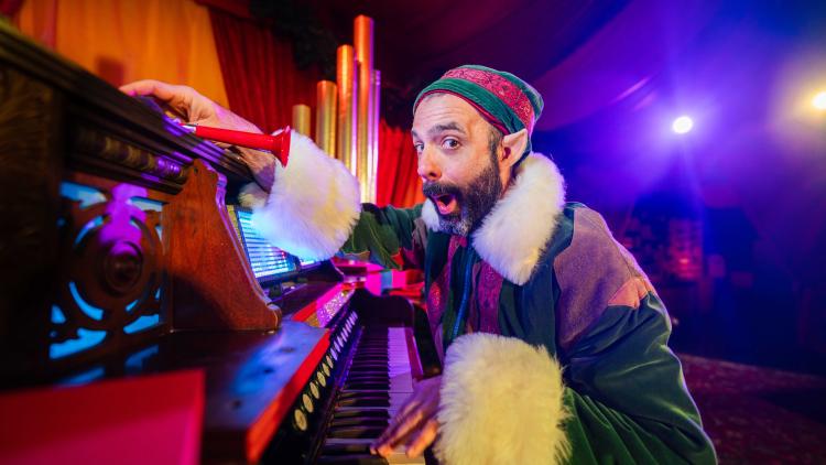Elf playing on a special Christmas musical instrument as part of Father Christmas show