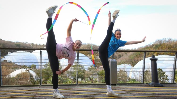 Two girls doing dance moves in front of Biomes