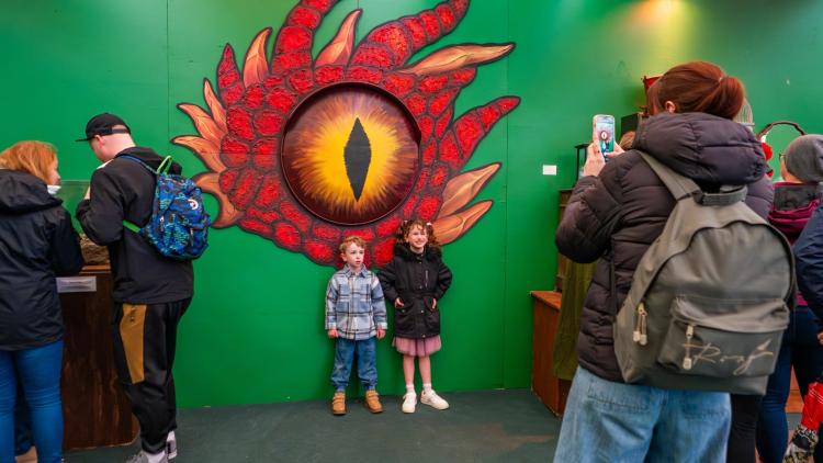 Children having photo taken in front of dragon mural