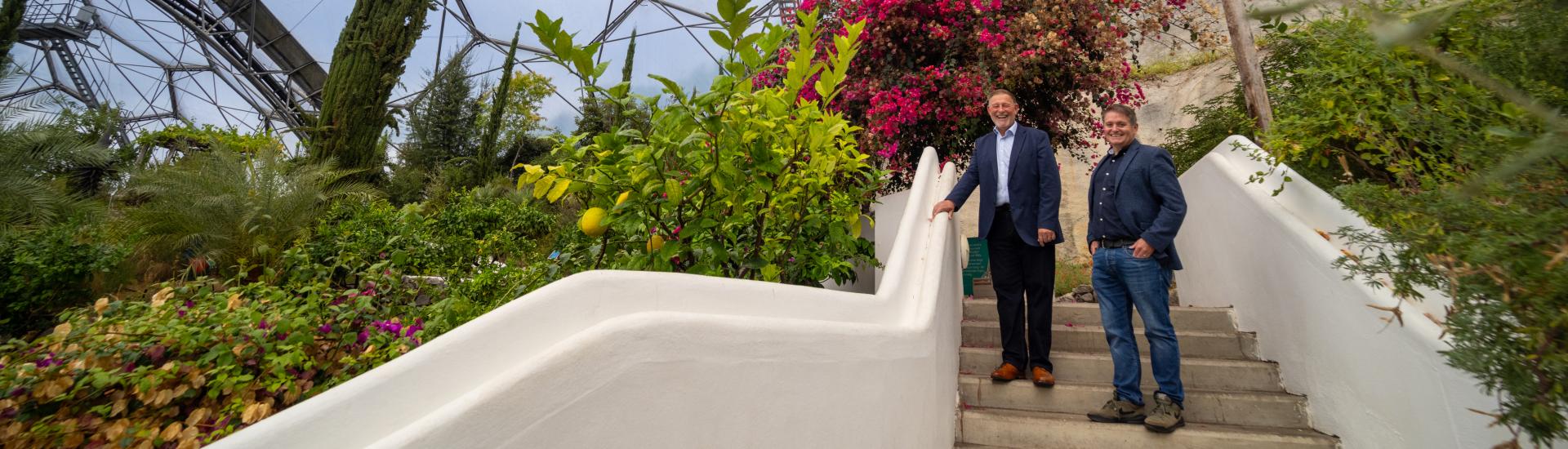 John Wilkinson from BAM and Dan James from the Eden Project stood on some steps in the Eden Project's Mediterranean Biome
